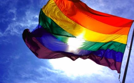 A pride flag waves in the wind