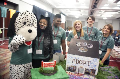 Students pose around a pet adoption table at the Colvard Student Union